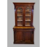 A Victorian mahogany bookcase, the moulded cornice above two glazed doors enclosing shelves, the