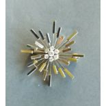 An 18ct gold diamond set brooch in the form of a star, the central diamond surrounded by six