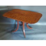 A 19th Century mahogany breakfast table, the tilt top above outswept legs with brass caps and