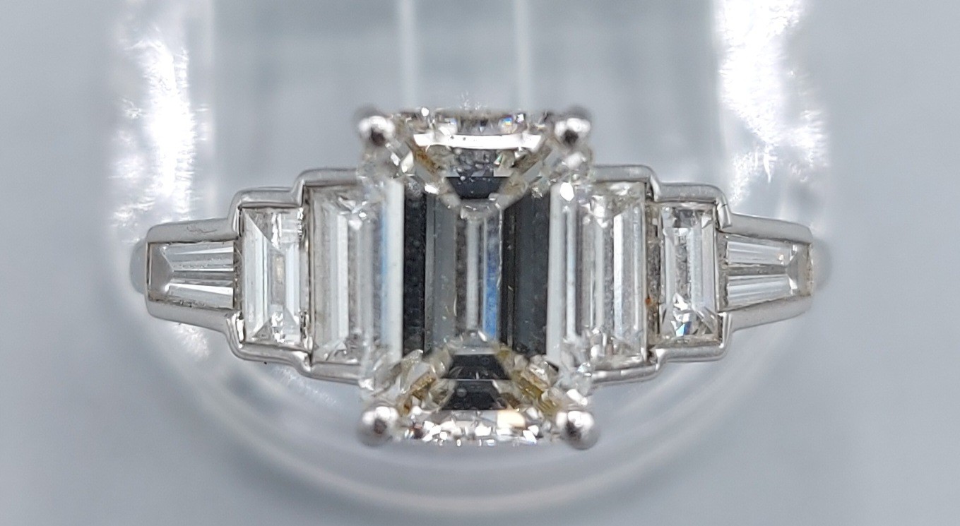 A Platinum diamond ring, the central 2.12ct Emerald cut diamond flanked by baguette diamonds