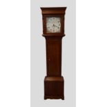 A George III oak longcase clock, the square hood with turned uprights above a rectangular door,