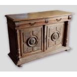 A French oak dresser base, the moulded top above two drawers and two carved panel doors flanked by