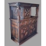 An oak Court Cupboard, the top with a central moulded door flanked by pierced column, the lower