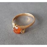 A 9ct gold ring set with a central yellow stone flanked by clear stones, 3.1gms