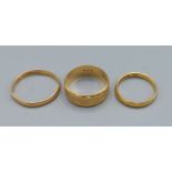 A 22ct gold wedding band together with two other 22ct gold wedding bands, 8.7 grams