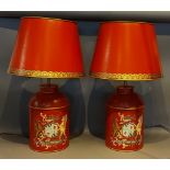 A pair of Toleware table lamps, each decorated with a crest upon a red ground together with Toleware