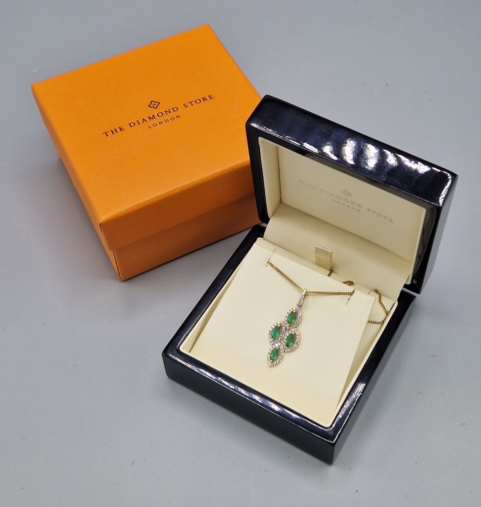 An 18ct gold pendant set with four emeralds surrounded by diamonds with a 925 silver chain, 32mm - Image 2 of 2