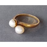 An 18ct gold crossover ring set with two pearls, 3gms