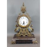 A French brass mantle clock, the enamel dial with Roman and Arabic numerals upon a marble and