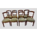 A set of eight Victorian walnut dining chairs each with a stuffover seat raised upon turned fluted