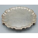 A George V sliver salver of shaped outline, with three scroll feet, London 1911, 20oz, 25cms