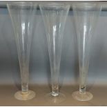 A set of three large glass spill vases of tapering form, 80cms tall