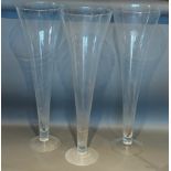 A set of three large glass spill vases of tapering form, 80cms tall