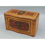 A satinwood and burr walnut serpentine fronted tea caddy, with brass inlaid decoration, 23cms wide