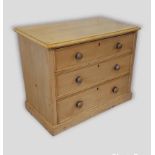 A pine chest of drawers, the moulded top above three long drawers with knob handles upon a plinth