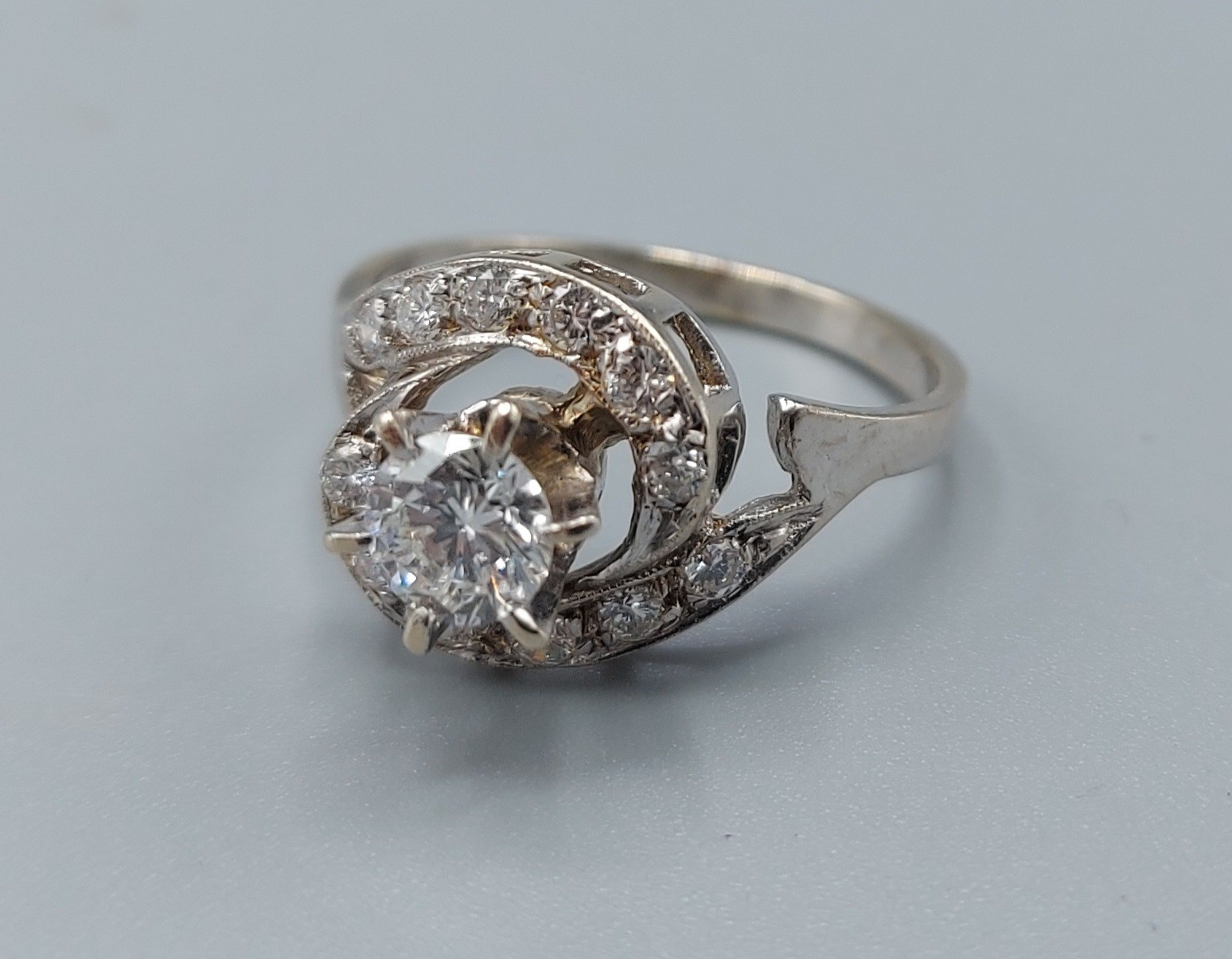 An 18ct white gold diamond cluster ring, the central diamond approx. 0.50ct surrounded by smaller