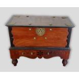 An Oriental metal mounted chest on stand, the moulded hinged top above two freeze drawers with