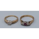 A 9ct gold three stone ring set with a central garnet flanked by diamonds 2.3gms, ring size N