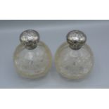 A pair of Edwardian silver and cut glass large scent bottles, decorated with whispers, Birmingham
