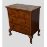 A Queen Anne style walnut chest of two short and two long drawers raised upon shell carved