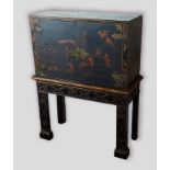 A 19th century lacquered cabinet on stand, the top with two panel doors decorated with figures and
