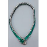 An early 20th Century paste necklace in the form of a snake set with clear and green stones