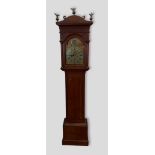 An oak longcase clock, the shaped hood with brass finials above a rectangular door and confirming