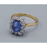 An 18ct gold Tanzanite and diamond cluster ring, with a central rectangular Tanzanite surrounded