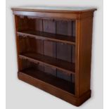 A Victorian oak narrow bookcase, the moulded top above shelves raised upon a plinth base, 122cm wide
