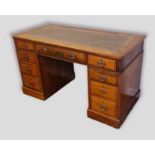 An Edwardian mahogany twin pedestal desk, the tooled leather inset top above nine drawers with brass