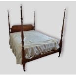 A mahogany four poster bed, the shaped headboard with four turned uprights with shaped finals raised