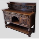 A Victorian carved oak sideboard with a low gallery back above two drawers with alcove and two