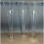 A set of three large glass spill vases of tapering form, 80cms tall