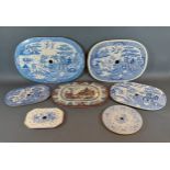 Four blue and white willow pattern decorated strainers, together with three other strainers