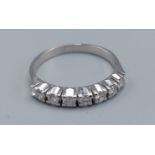 A 14ct white gold diamond set band ring, set with seven diamonds within a pierced setting, ring size