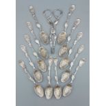 A set of twelve 18th Century silver naturalistic rococo teaspoons with a pair of matching sugar nips