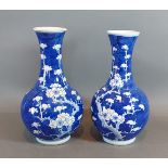 A pair of Chinese underglazed blue prunus blossom decorated bottle neck vases, six character marks