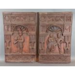 A pair of carved wooden panels depicting figures, 49cms by 41cms