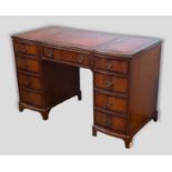 A twin pedestal desk, the tooled leather inset top above nine drawers together with a mahogany