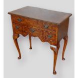 A 20th Century lowboy, the crossbanded top with pinched corners above four drawers with shaped apron