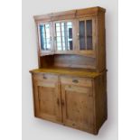 A pine dresser, the top with shaped moulded cornice and three glazed doors above a moulded top