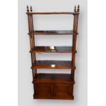 A 20th Century hardwood and brass inlaid bookcase with open shelves above two doors raised upon a
