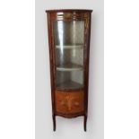 A French Louis Xv style bow fronted corner cabinet with metal mounted and inlaid glazed door