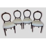 A set of four balloon back dining chairs, with carved backs above stuff over seat raised upon turned