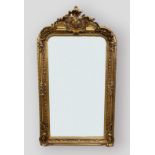 A gilt over mantle mirror with carved cresting and foliate decorated frame, 155cms by