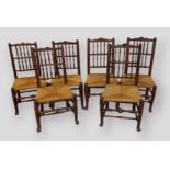 A Set of Six 19th Century Elm Lancashire Spindle Back Dining Chairs with rush seats raised upon