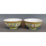 A pair of Chinese porcelain bowls, each decorated in polychrome enamels upon a yellow ground, six