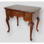 A 20th Century walnut lowboy in the 18th Century style, the moulded top with pinched corners above