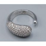 An 18ct white gold diamond cluster ring of stylised for with open band, ring size P, 6.2gms