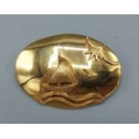 An 18ct gold brooch of oval form decorated with a sailing vessel, 8.2gms